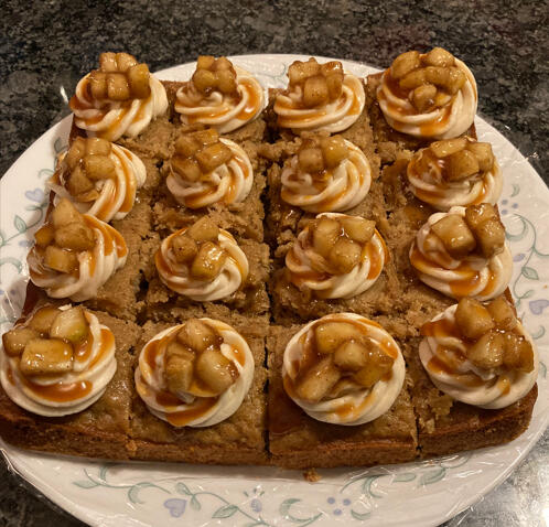 apple spice cake with brown sugar icing, baked apples, and a salted caramel drizzle